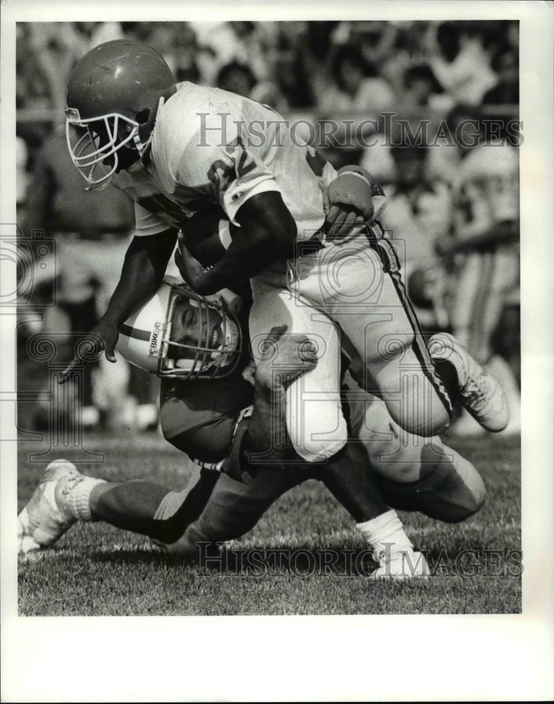 1985 Press Photo Thomas Smallwood Dragged by Scott Scheper in Football Action - Historic Images