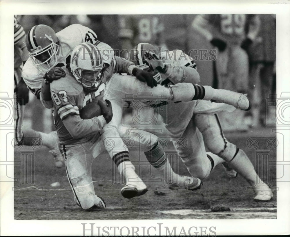 1985 Press Photo Tim Smith is tackled by Frank Minnifield and Clay Mathews- Historic Images