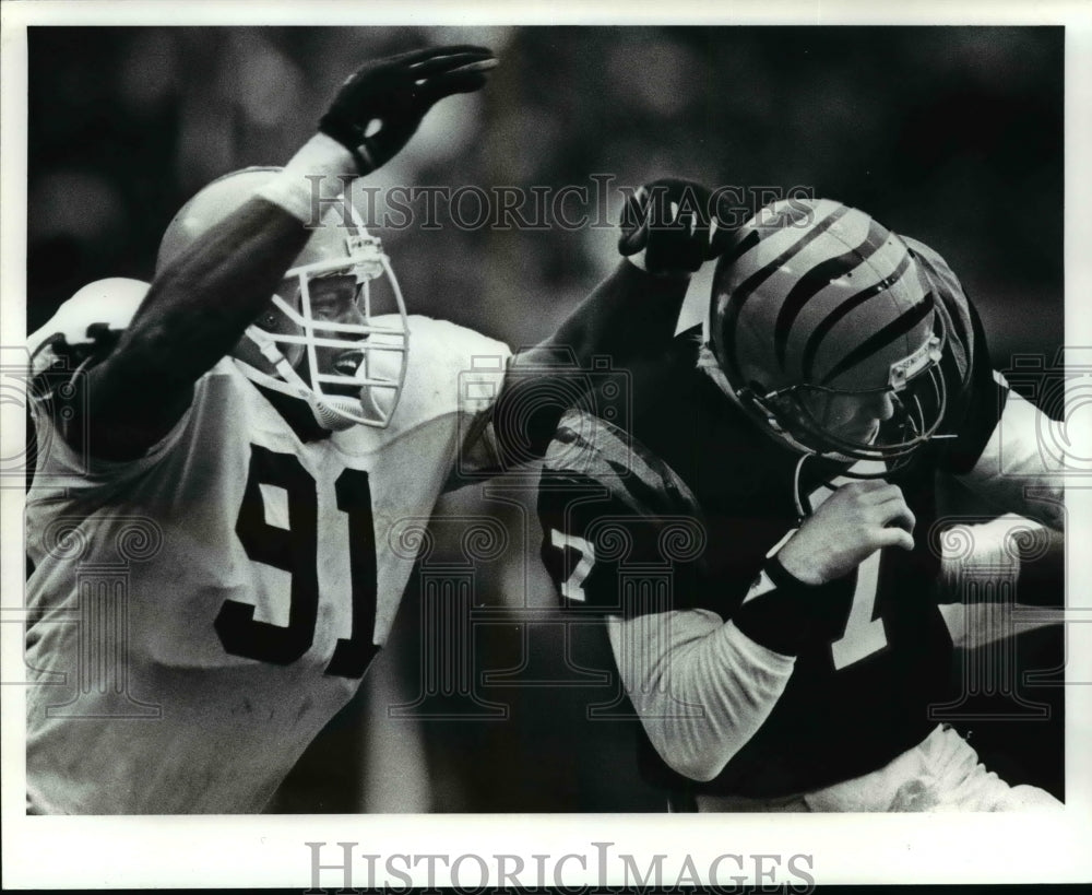 1987 Press Photo Sam Clancy hammers Boomer Esiason of Bengals in football game. - Historic Images