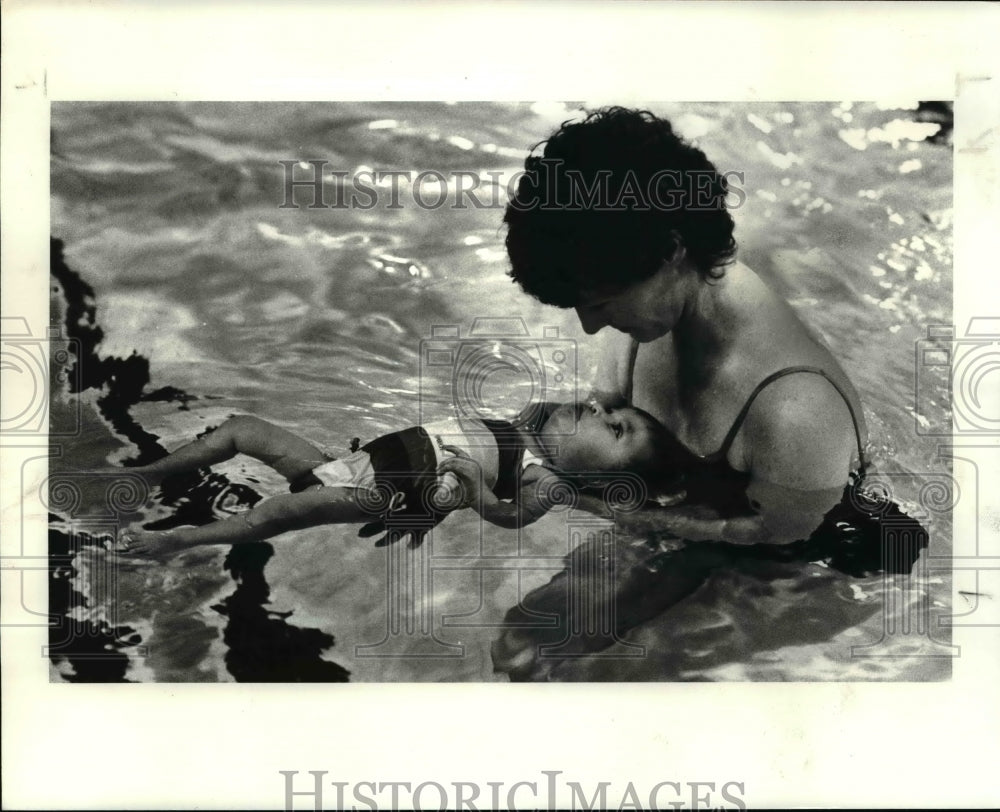 1983 Press Photo: Cartha Murphy holds Angie in a float at the Heights YMCA - Historic Images