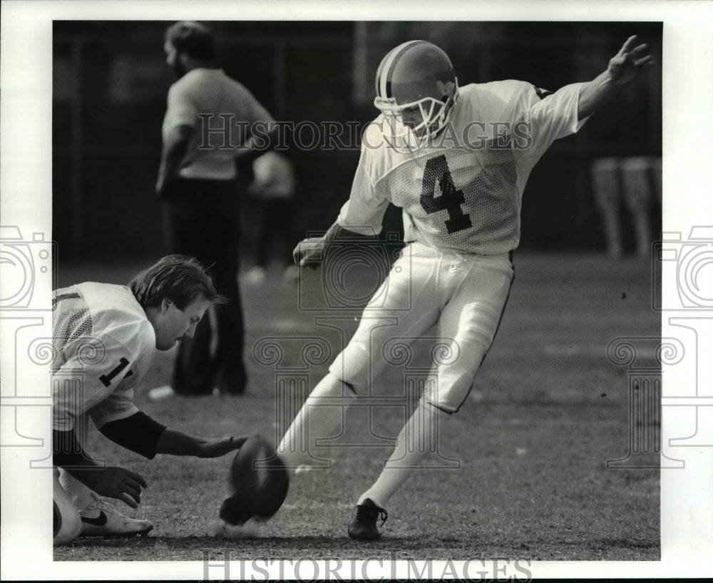 1987 Press Photo Brian Franco kicks for Browns, holding is Christensen. - Historic Images