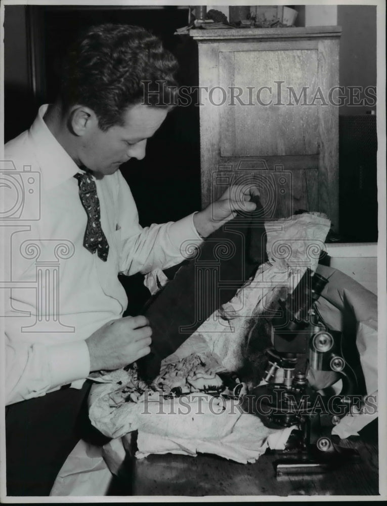 1951 Press Photo Det. Wm. J. Brady is shown as he examines bits of clothing - Historic Images