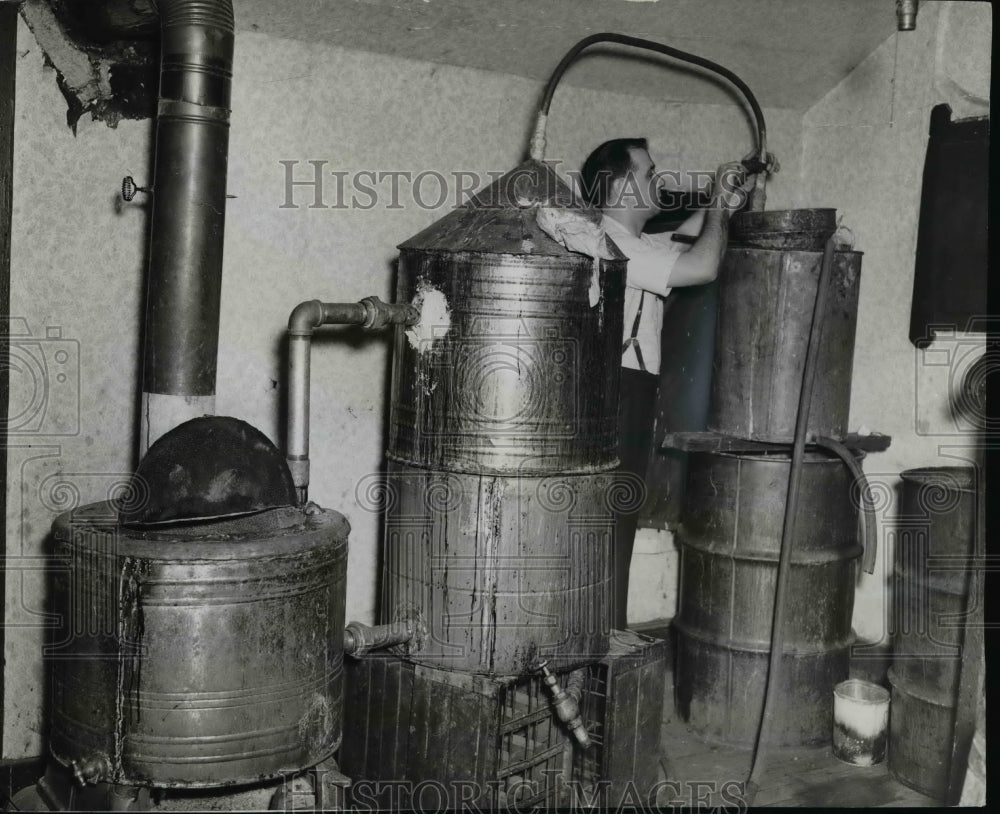 1941, Patrolman Carl Primosch dismantles a giant still discovered - Historic Images