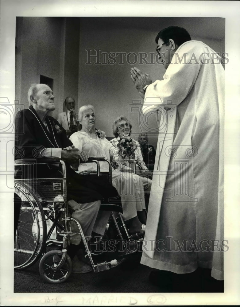 1987 Press Photo Rev Fr Joseph Goebel blesses Robert and Mildred at the Hospital - Historic Images