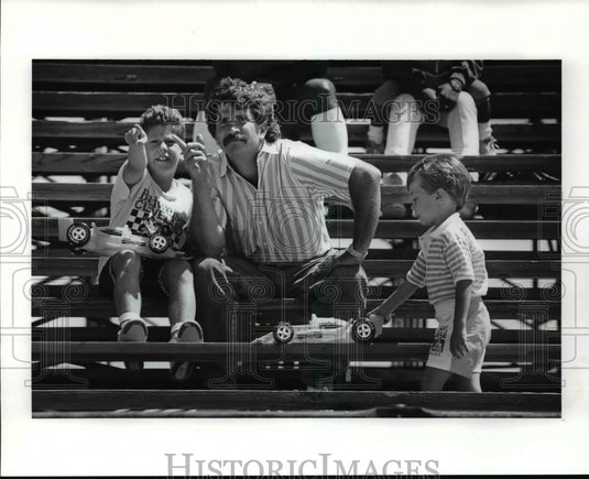 1989 Press Photo Brian Mabie and Eric Talk over Race as Matthew Races the stands - Historic Images