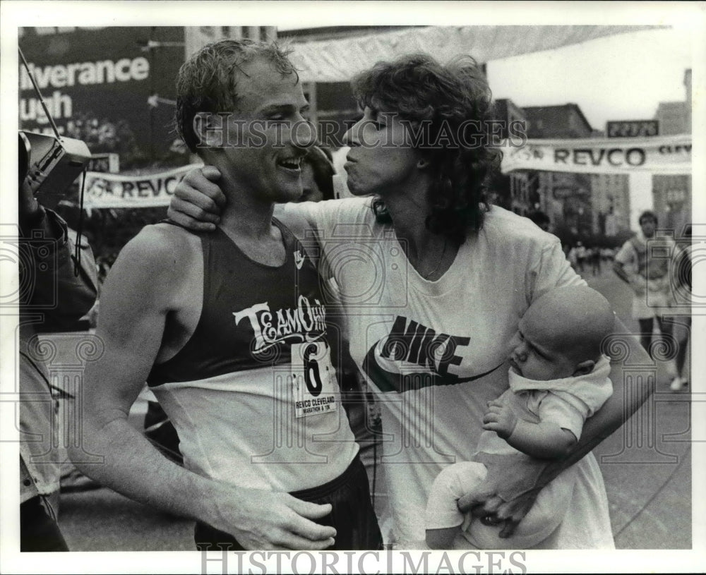 1986 Press Photo Ted Rupe gets a kiss from his wife Michelle with son Craig - Historic Images