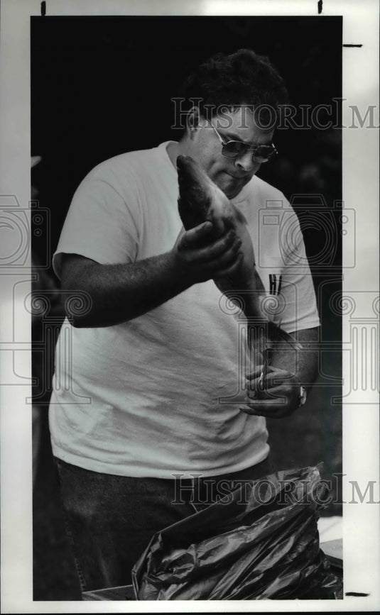 1990 Press Photo Eugene Friedl clips the tail on a walleye that was caught - Historic Images