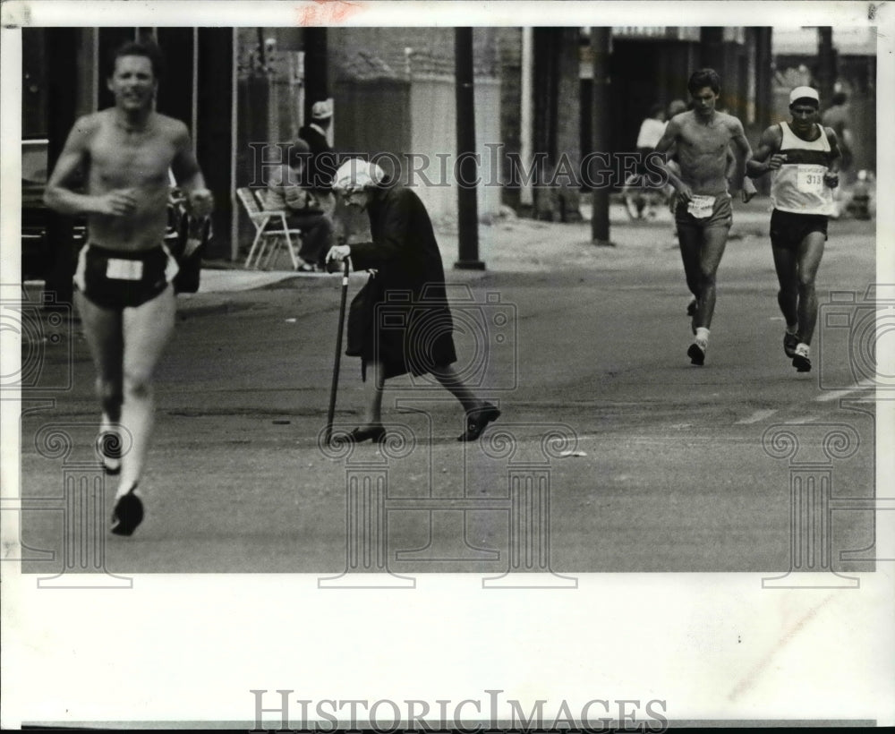 1982 Press Photo Elderly Woman makes her way thru the runners as she crosses - Historic Images
