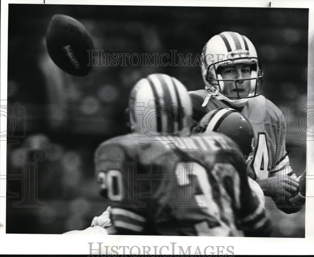 Press Photo: Oilers QB Brent Pease dumps off a pass to RB Herman Hunter - Historic Images