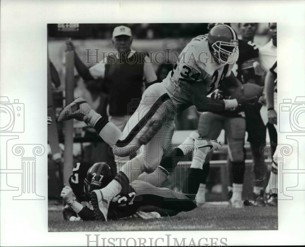 1990 Press Photo Kevin Mack is upended after gaining 1st down yardage in 1st qtr - Historic Images