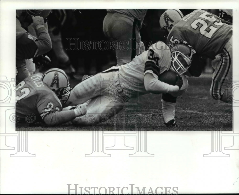 1986 Press Photo Mack runs for 3 yards in the 1st qtr. Robert Lyles, stopps him - Historic Images