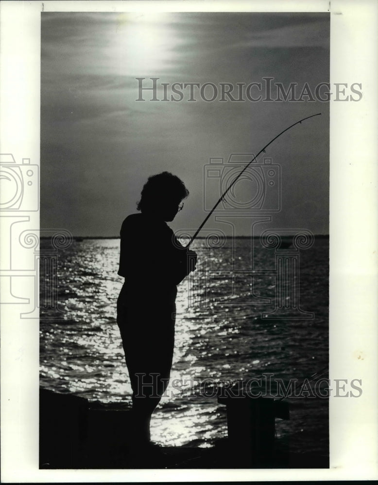 1990 Press Photo Gloria Davis, of Cleveland, fishes off Cleveland lakefront - Historic Images