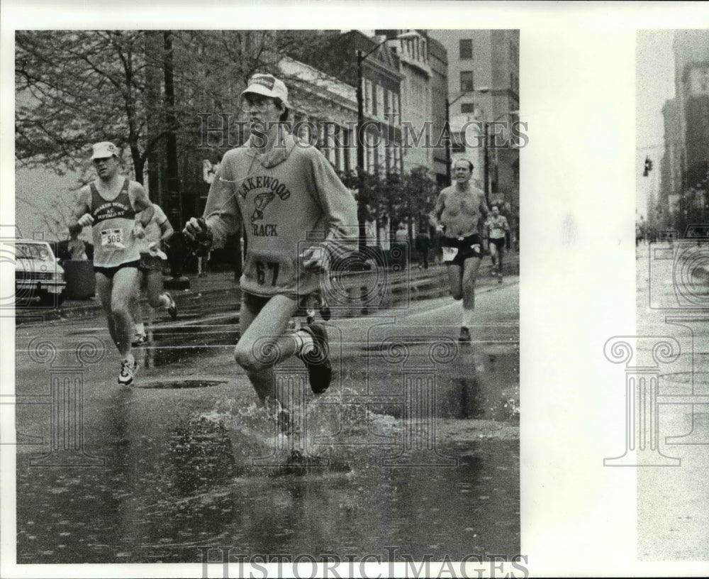 1984 Press Photo Runners splash thru the water at 18 Euclid during the marathon - Historic Images