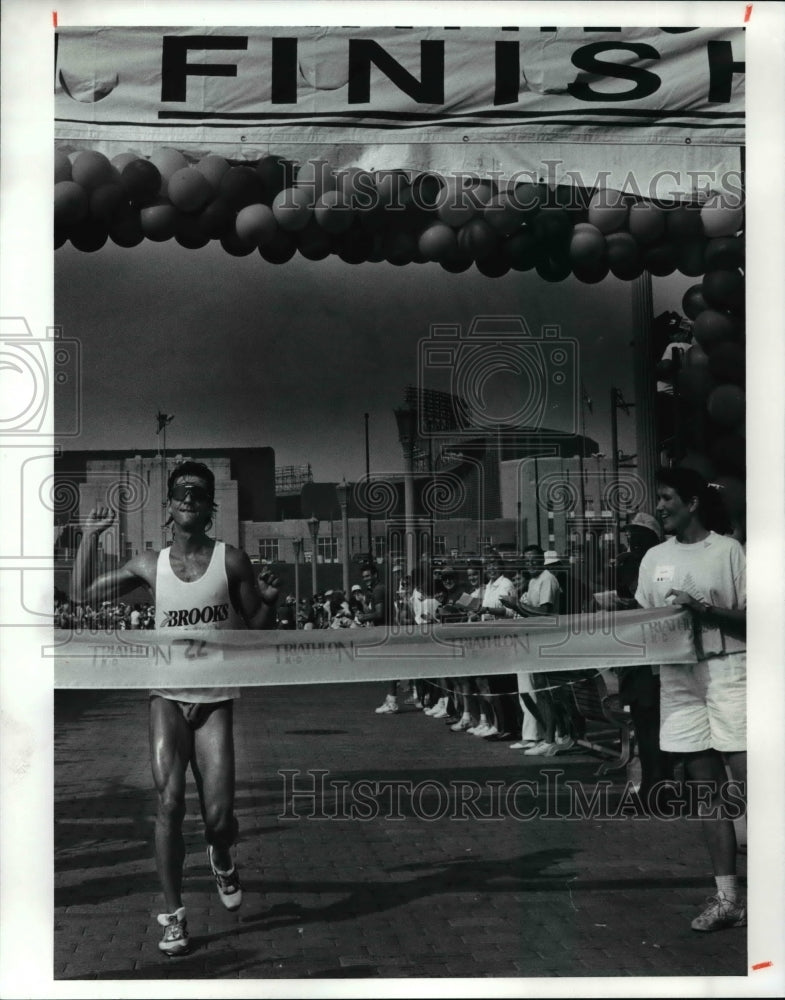 1990 Press Photo Scott Molina raises his fist as he hits the tape, NCC Triathlon - Historic Images