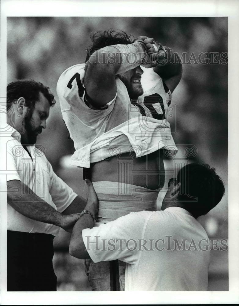 1988 Press Photo Bob Golic grimace in pain as he has stomach re-taped - Historic Images