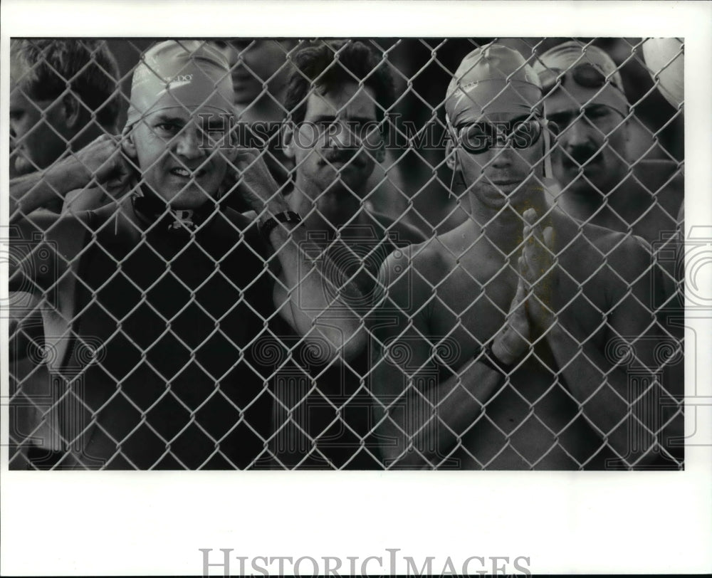 1991 Press Photo: Amateur triatheletes nervously wait their turn to begin swim - Historic Images