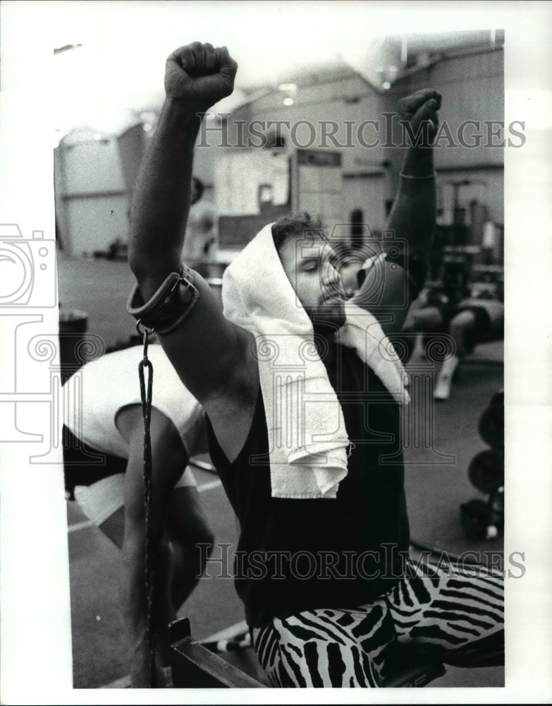 1988 Press Photo Bob Golic exercising his shoulder muscles at Browns training. - Historic Images