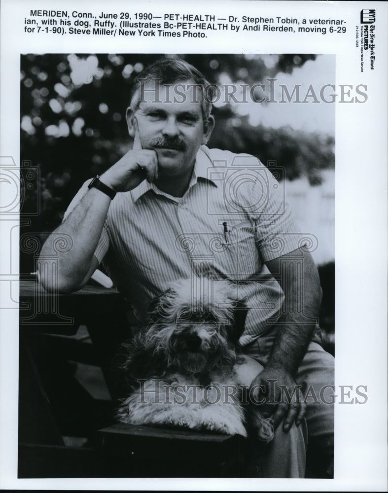 1990 Dr. Stephen Tobin, a veterinarian, with his dog, Ruffy. - Historic Images