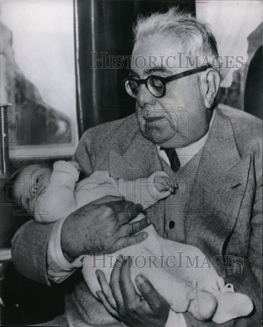 1950 Aga Khan holds his 12-weeks-old granddaughter at Gstaad - Historic Images