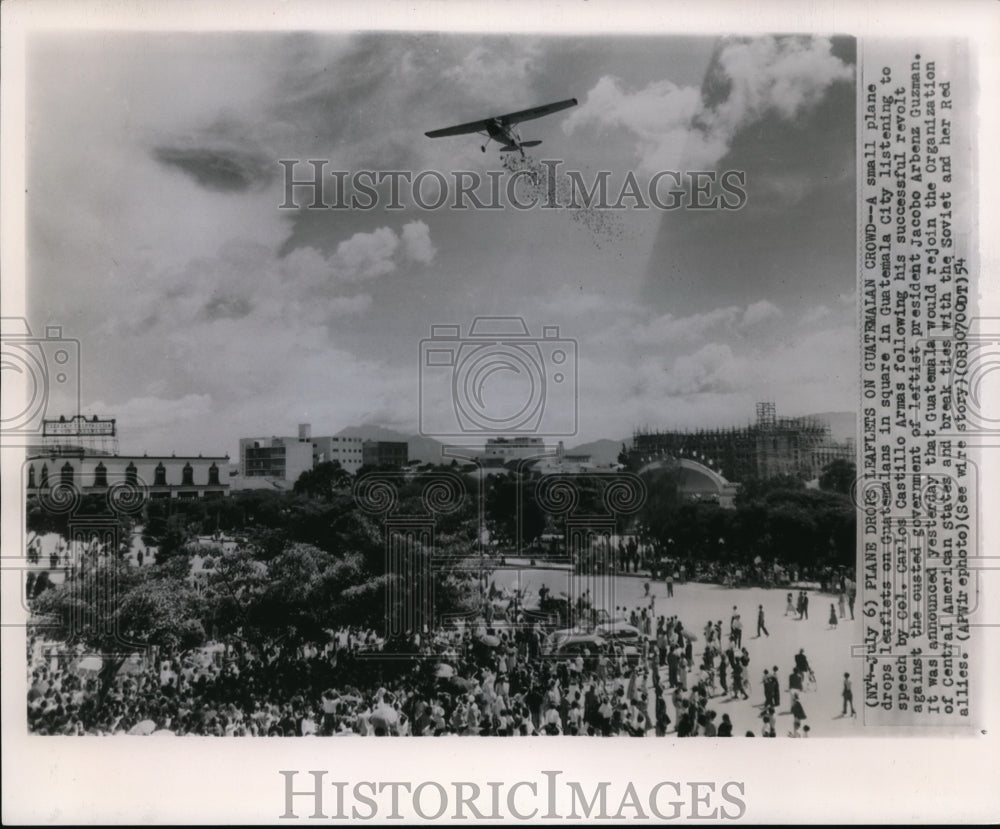 1954 Small plane drops leaflet on Guatemalans listening to speech - Historic Images