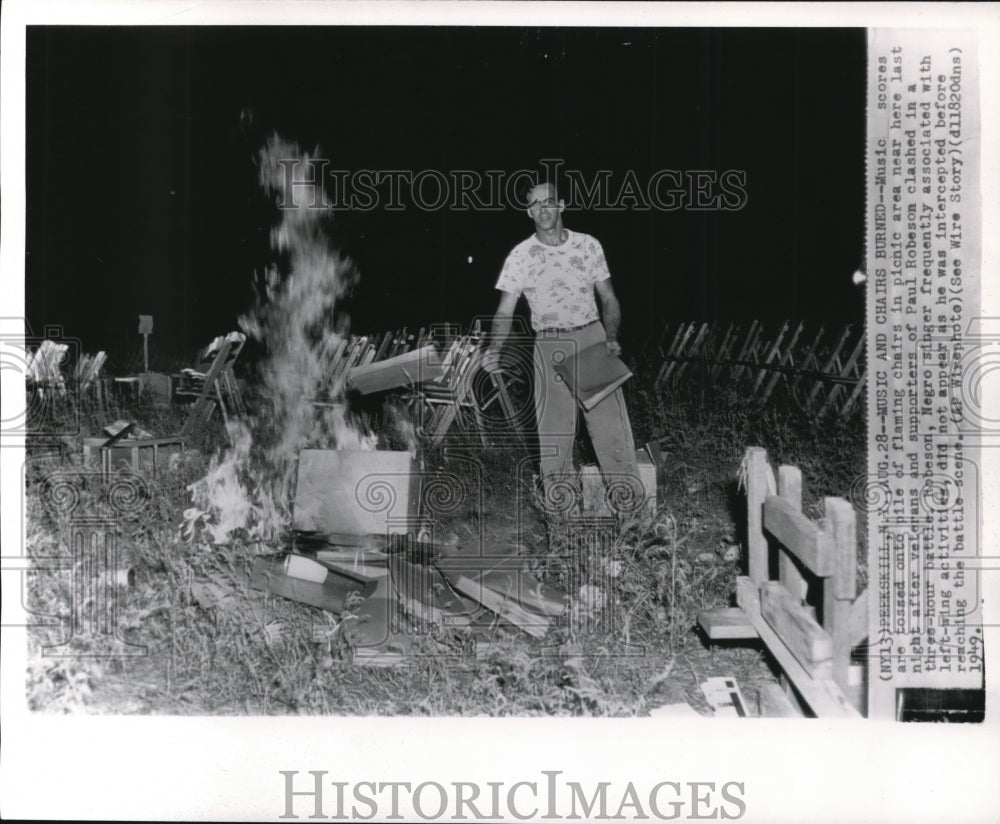 1949 Press Photo Music scores tossed onto pile of flaming chair - Historic Images