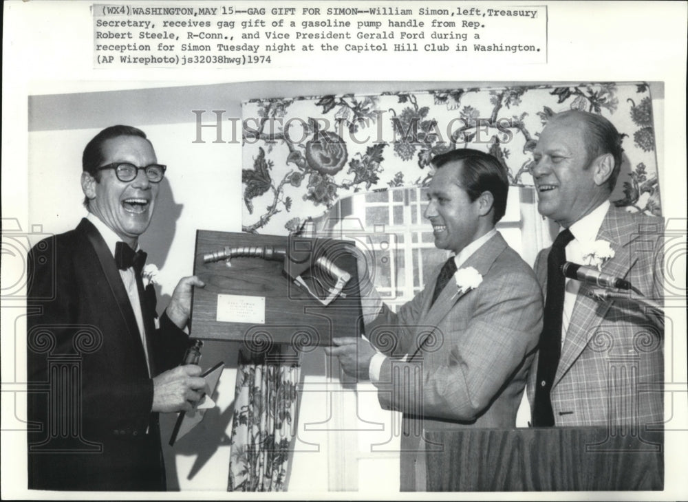 1974 Press Photo William Simon, Treasury Sec, receives gag gift of gas pump - Historic Images