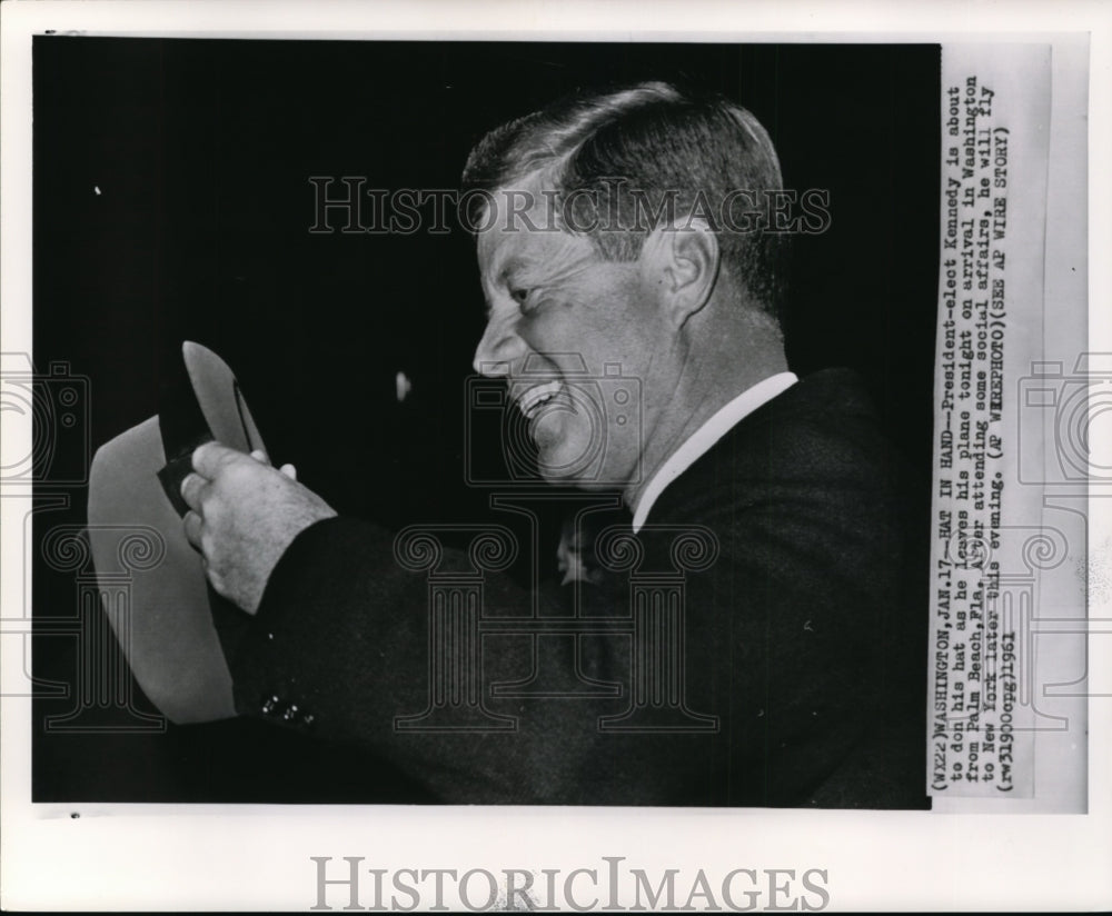 1961 Press Photo President-elect Kennedy is about to don his hat as leaves - Historic Images