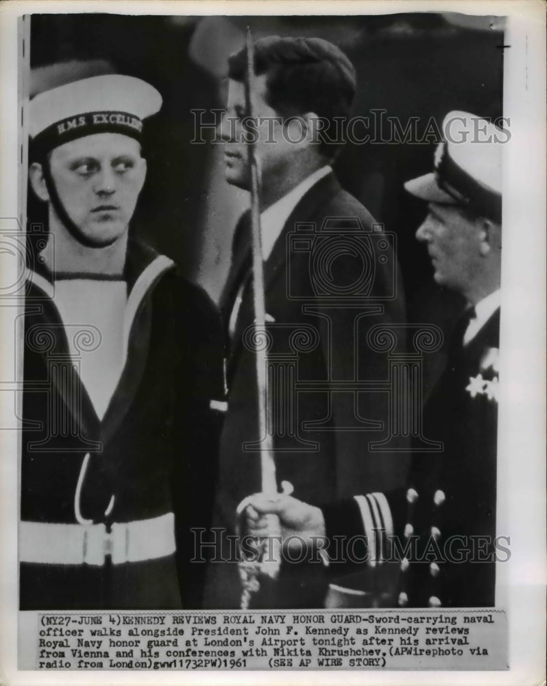 1961 Press Photo Sword-carrying naval officer walks alongside President John F. - Historic Images