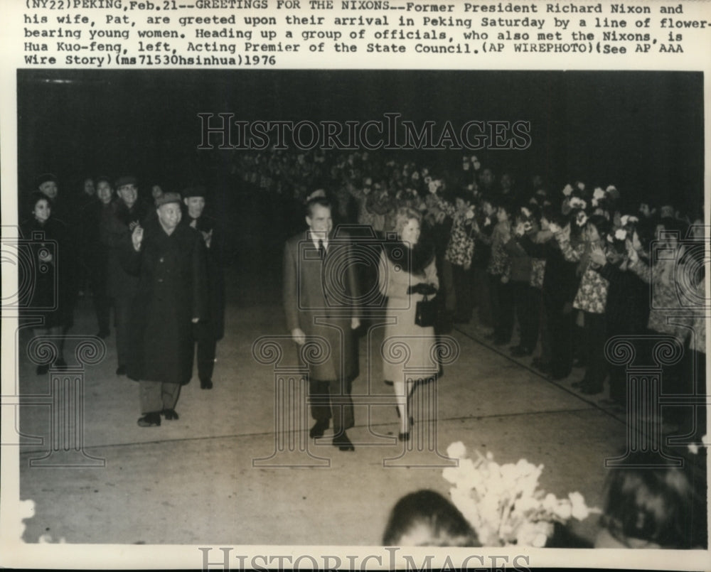 1976 Press Photo Nixons in arrival at Peking on line of flower bearing women - Historic Images