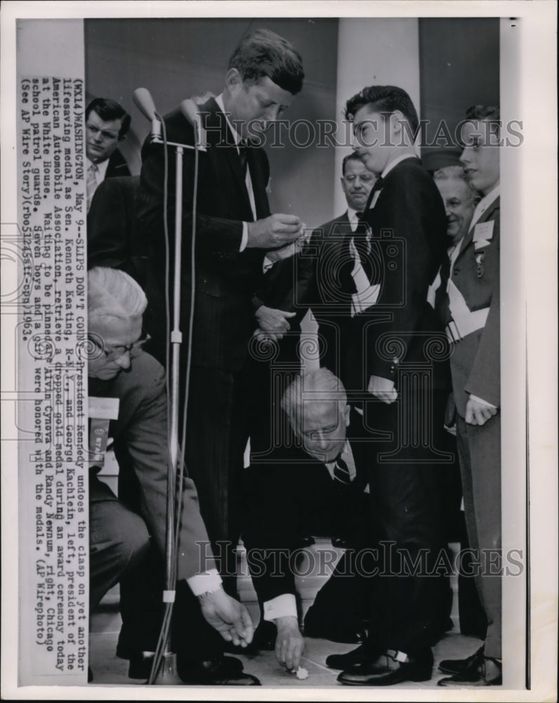 1963 Press Photo Pres Kennedy undoes the clasp on yet another lifesaving medal - Historic Images