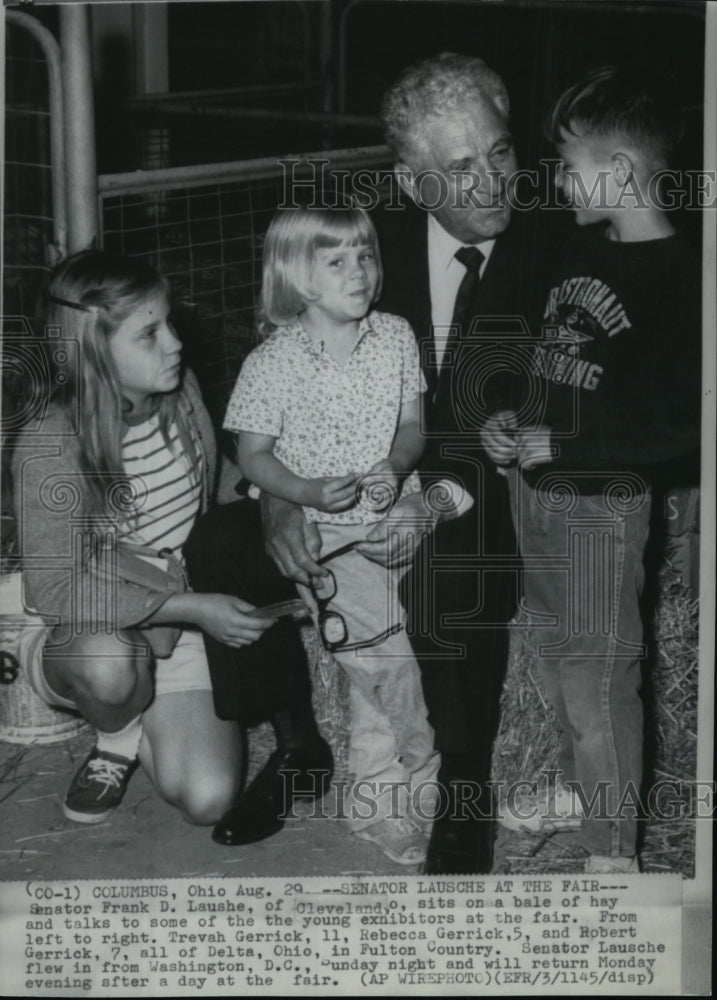 1967 Press Photo Sen. Frank D. Lausche sits on a blae of hay and talks to some - Historic Images