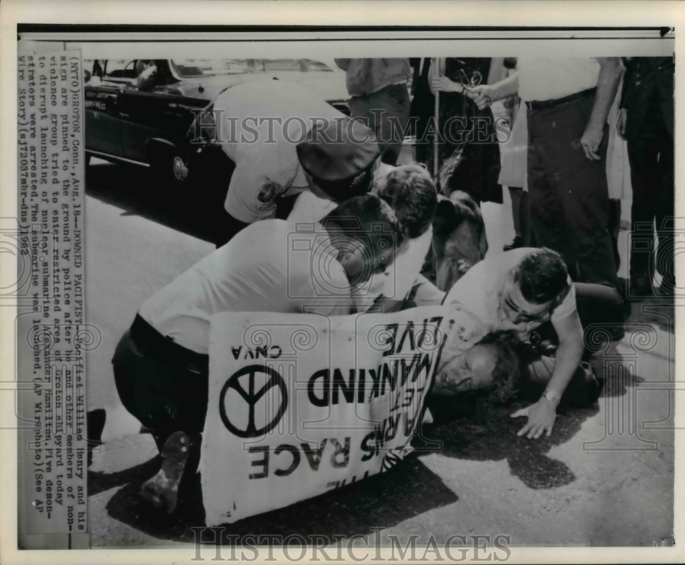 1962 Press Photo Pacifist William Henry and his sign are pinned down - Historic Images