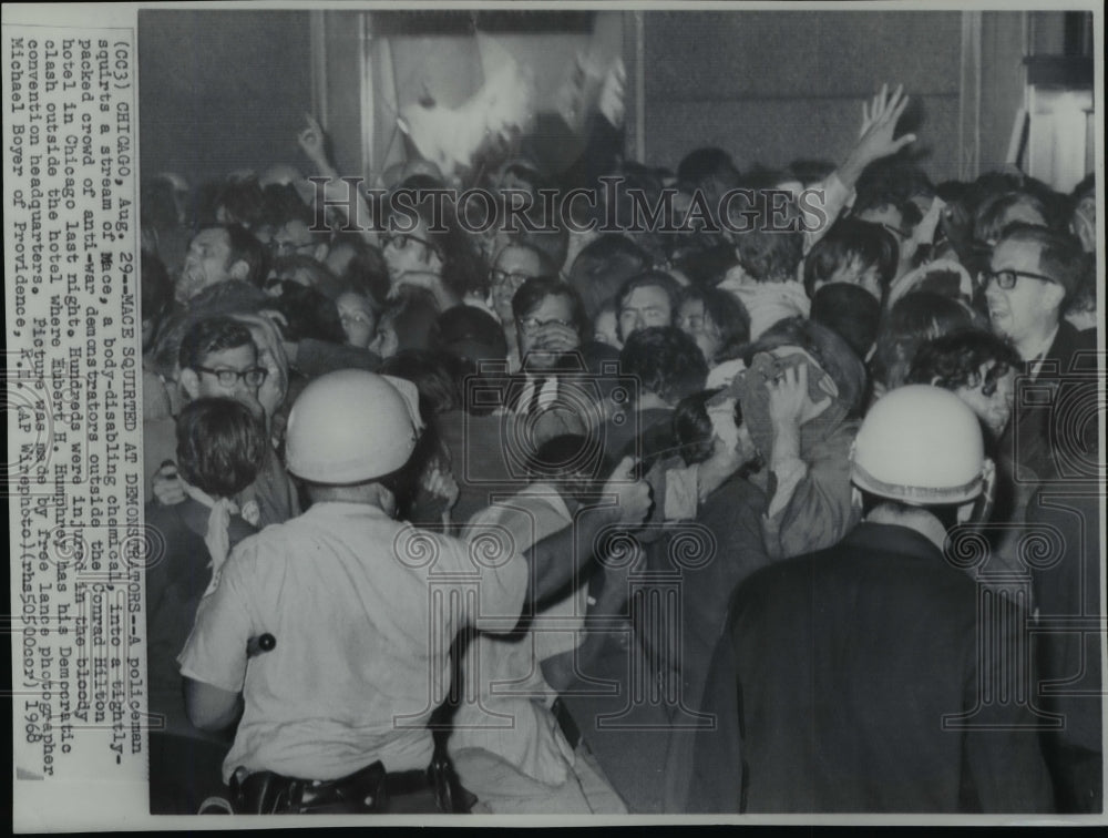 1968 Policeman disbursing mase into crowd of anti war demonstrators - Historic Images