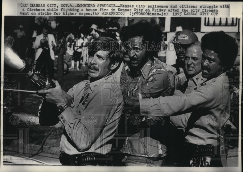 1975 Press Photo Kansas City policemen, citizen struggle w/ firehouse in Kansas - Historic Images