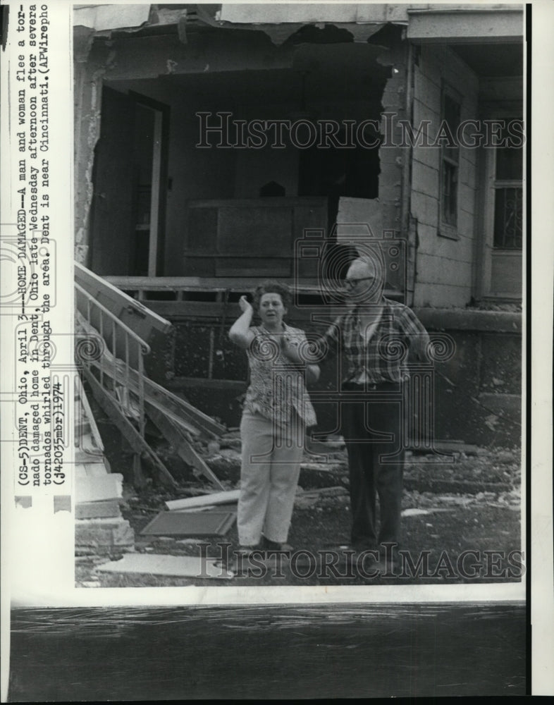 1974 A man and woman flee a tornado damaged home in Dent, Ohio - Historic Images