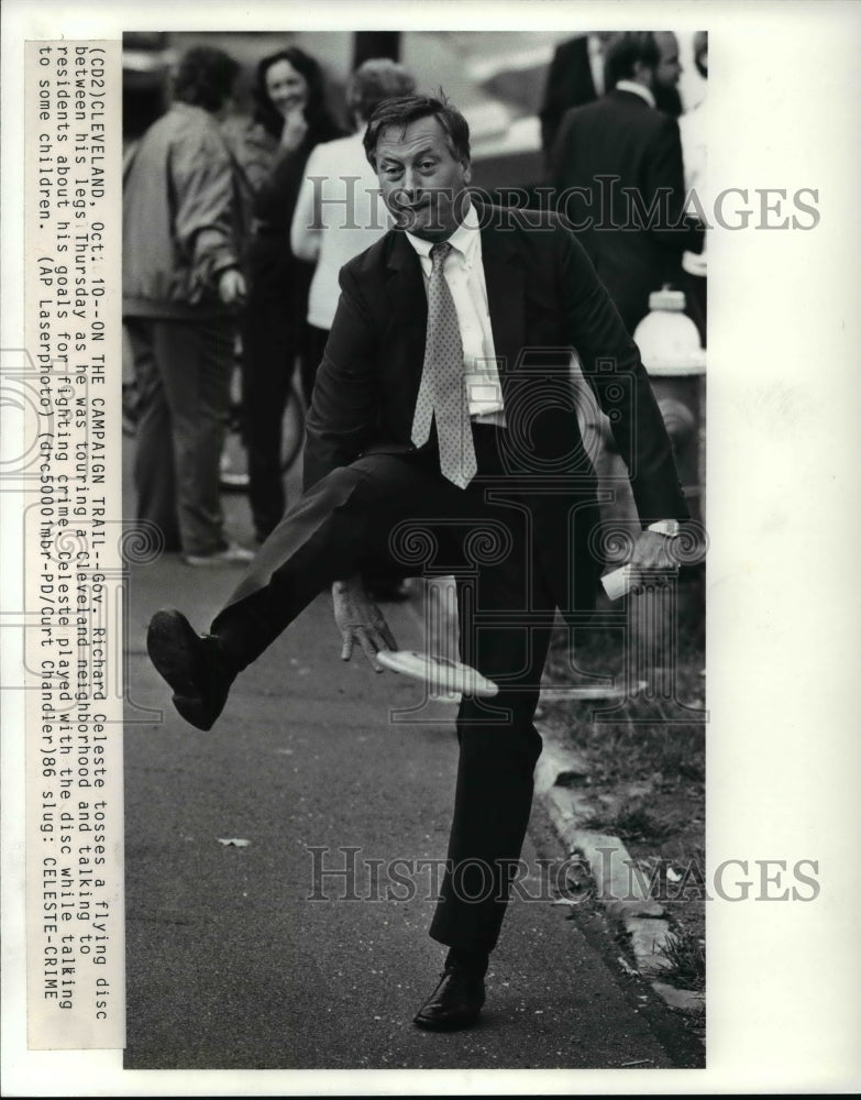 1986 Press Photo Ohio Gov Richard Celeste tosses a flying disc between his legs - Historic Images