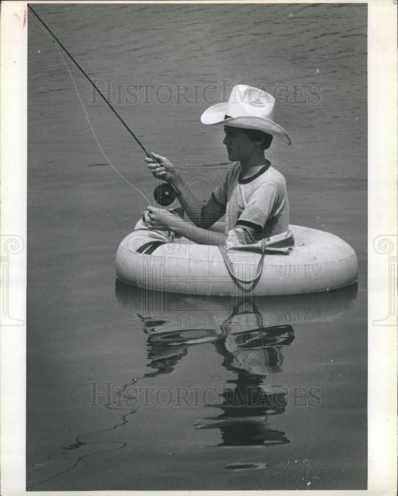 1980 Press Photo Young fisherman inner tube - Historic Images