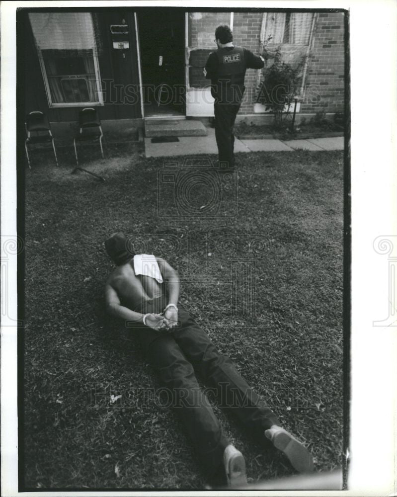 1990 Press Photo suspect lies handcuffed officers raid - Historic Images