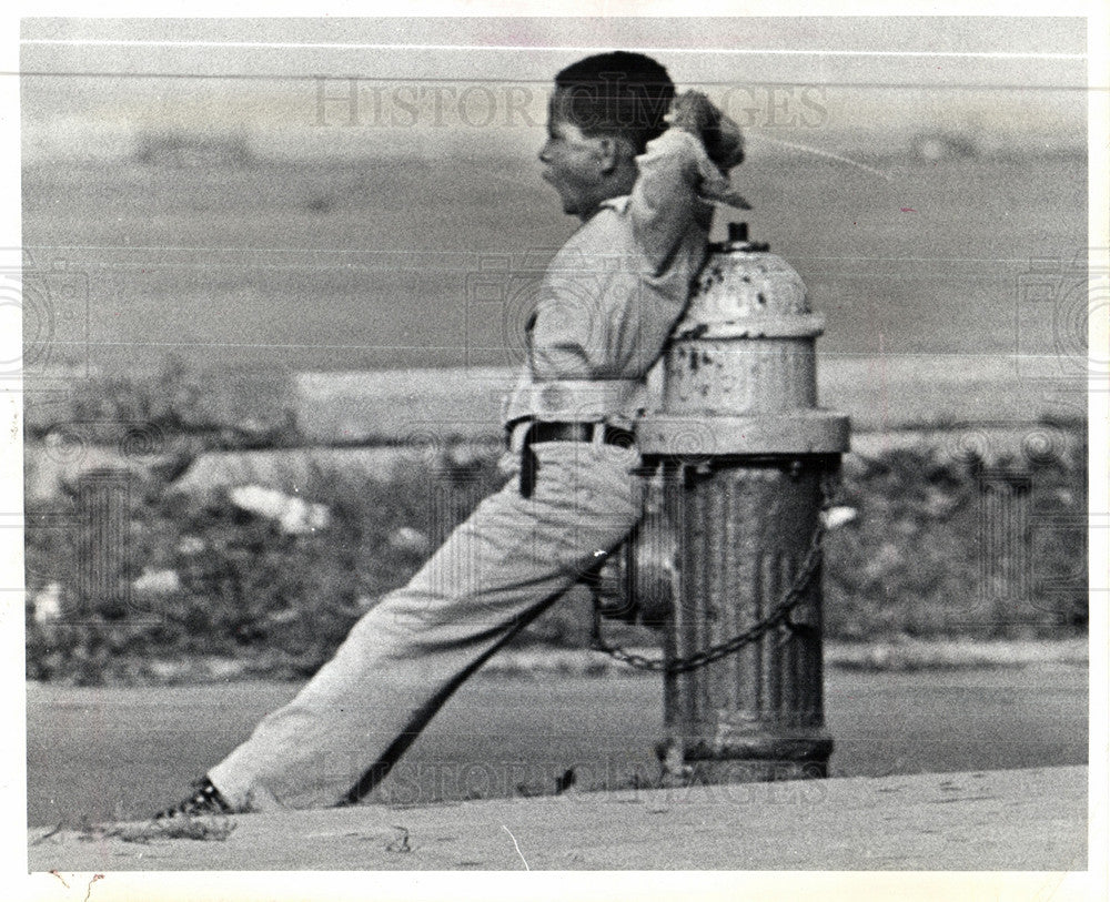 1974 Press Photo Young safety guard relaxes on hydrant. - Historic Images