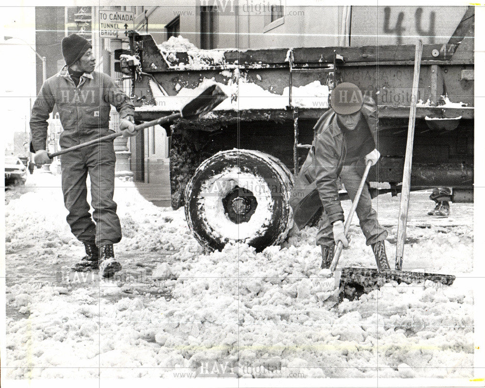 1977 Press Photo Snow shoveling, water board building - Historic Images