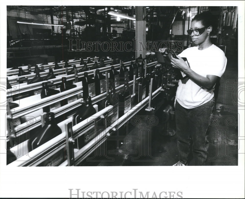 1990 Press Photo Wilma Levy checks measurements of Texaco oil bottles - Historic Images