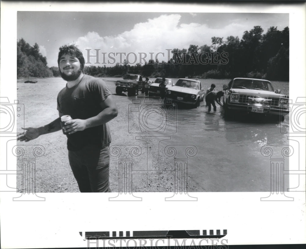 1985 Press Photo Tony Aguilar and his friends was their cars in Brazos River, TX - Historic Images