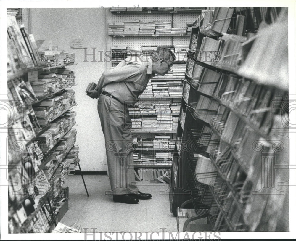 1984 Press Photo Customer surveys books at the Book Center - hca12238 - Historic Images