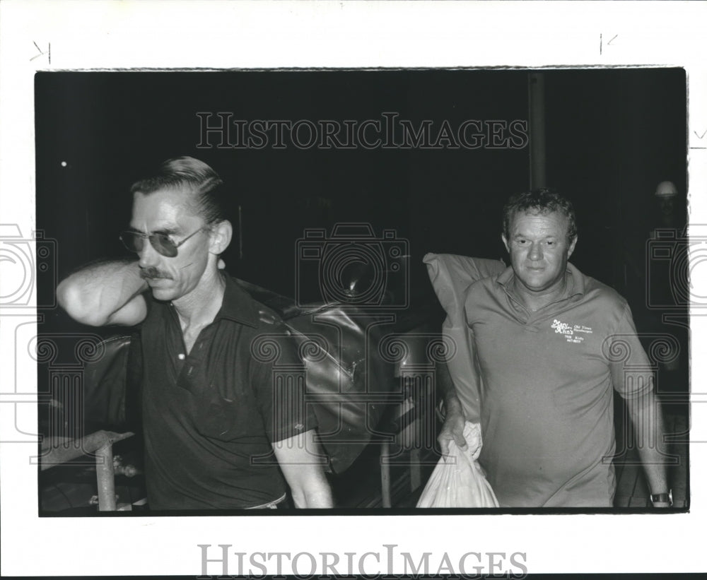 1986 Press Photo Ralph Henry &amp; Alfred Rowell Toting Articles from Sunken Boat. - Historic Images