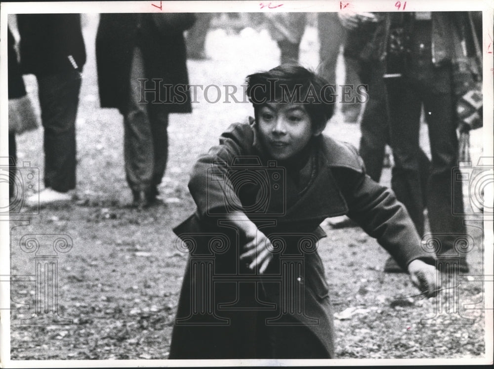 1973 Press Photo A Chinese youth hurls a fire cracker during Chinese New Year - Historic Images