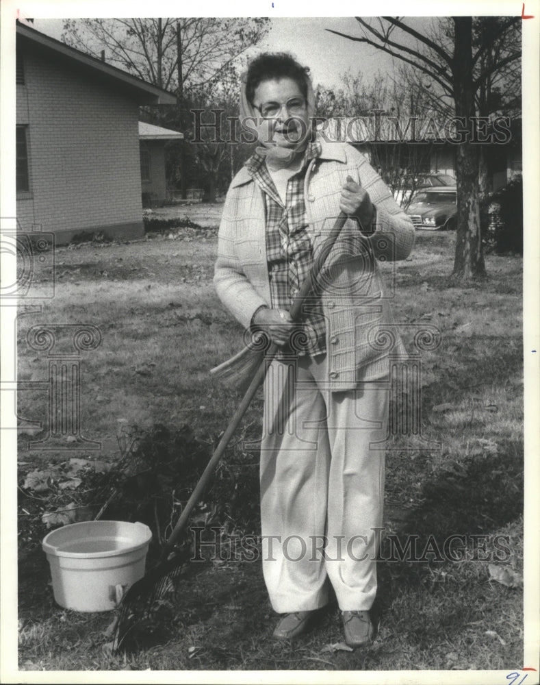 1983 Press Photo Lela Westfall rakes leaves at housing project, Clarksville, TX - Historic Images