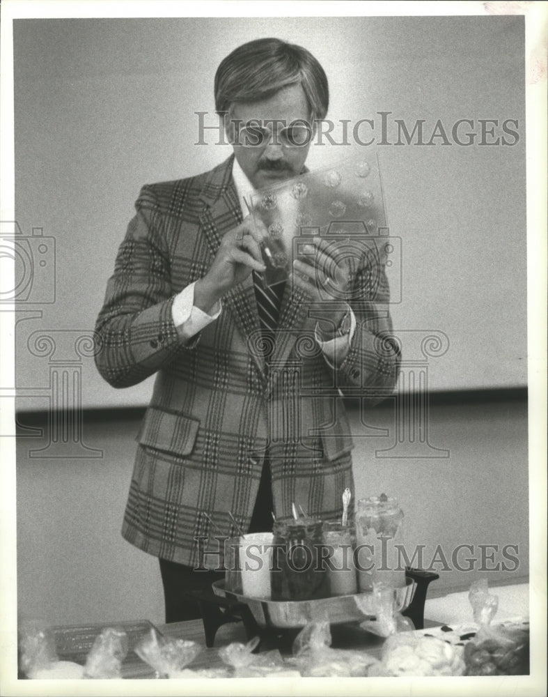 1984 Press Photo Man Scoops Chocolate from Mould. - hca12693 - Historic Images