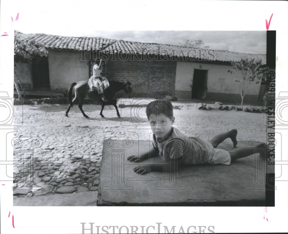 1992 Press Photo Salvadoran Boy Rests on Concrete Slab in Village of Suchitoto. - Historic Images