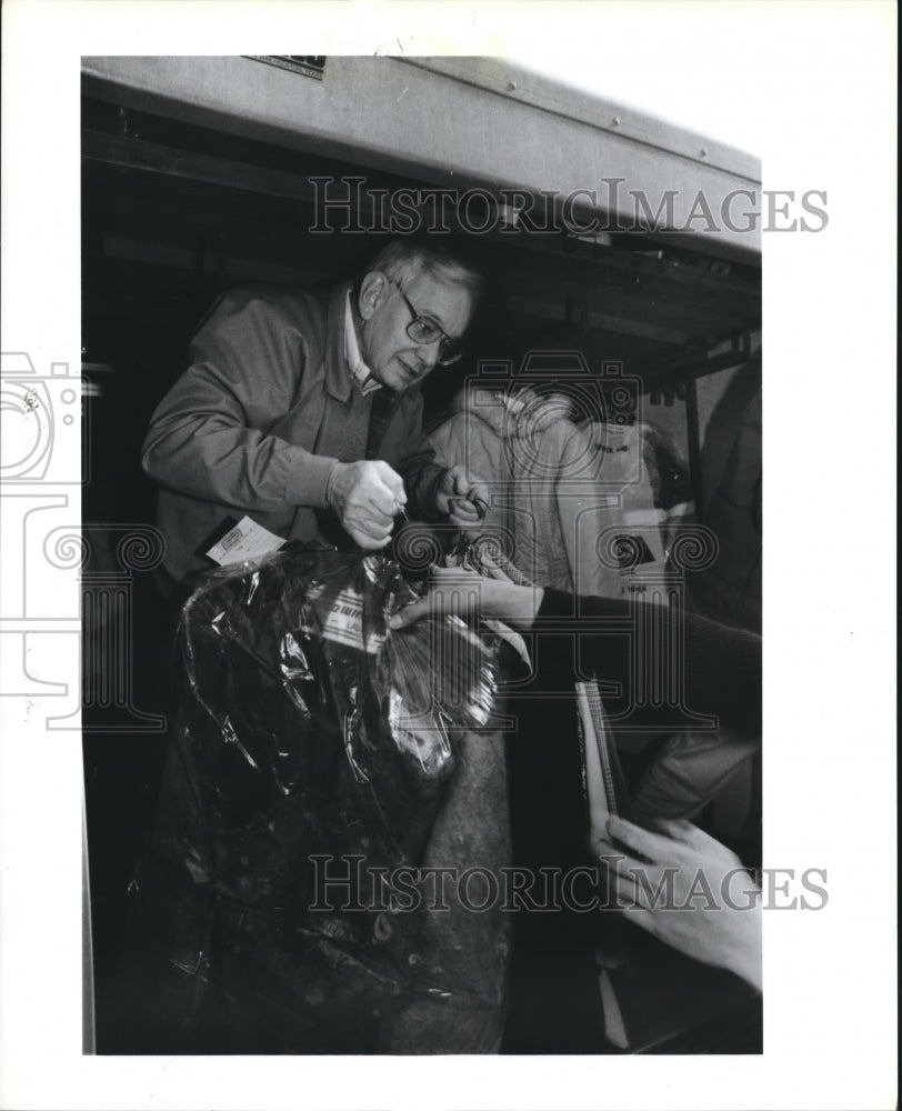 1989 Mart Allen Hands Clothing to Allens Halmark Cleaners Volunteers - Historic Images