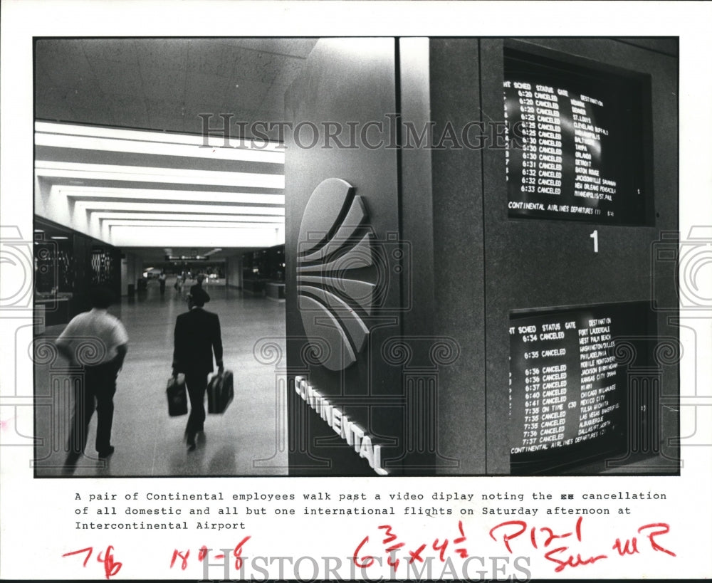 1983 Press Photo Continental Airlines Employees Walk Past Video Display, Houston - Historic Images